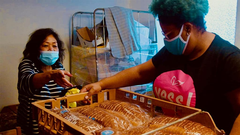 Twee vrijwilligers sorteren brood in de weggeefwinkel Yess!