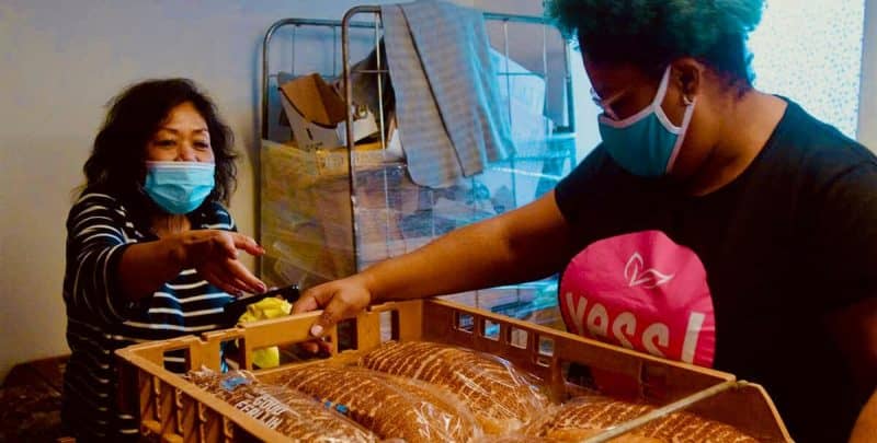 Twee vrijwilligers sorteren brood in de weggeefwinkel Yess!